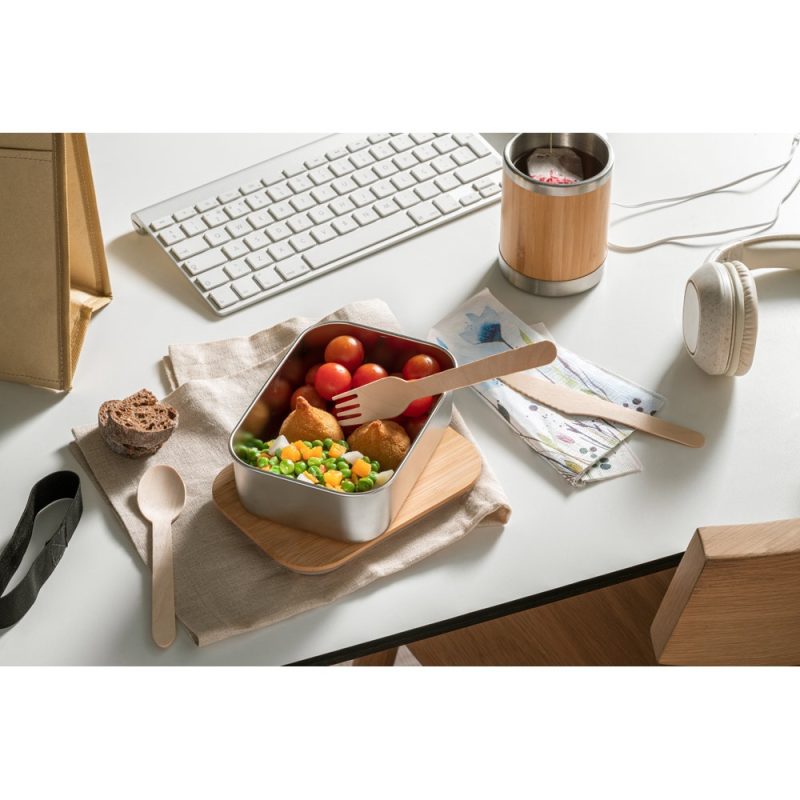 Office desk with lunch in bento box and utensils.