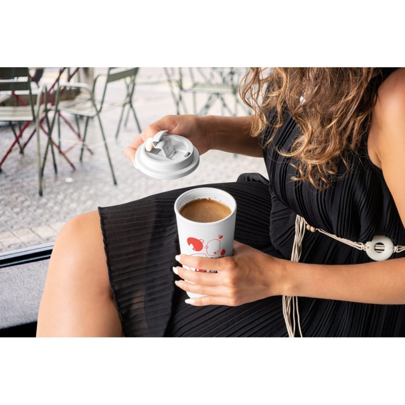 Woman holding coffee cup with lid off.