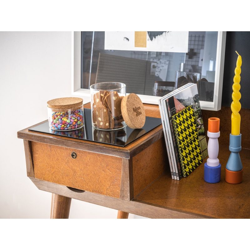 Decorative desk with jars, candles, and magazines.
