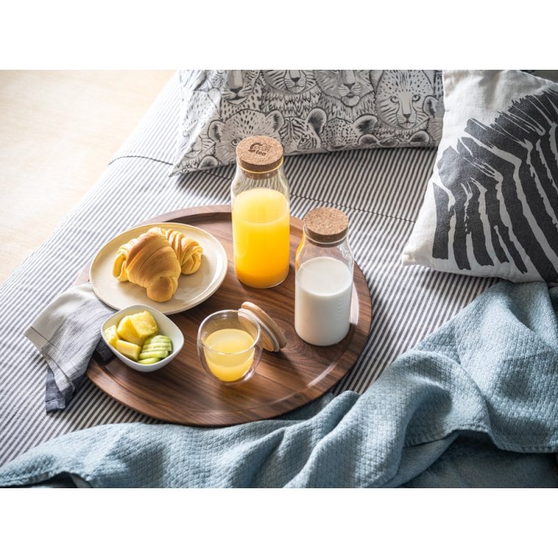Breakfast tray with juice, milk, pastries and fruit.