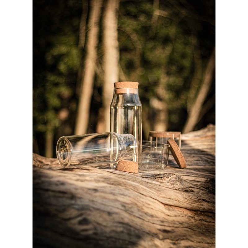 Glass bottles with cork stoppers on wooden log.
