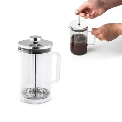 Hands using a glass French press coffee maker.