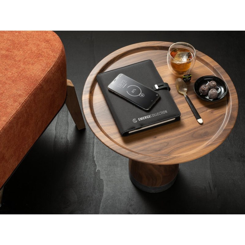 Round table with notebook, phone, tea and chocolates.