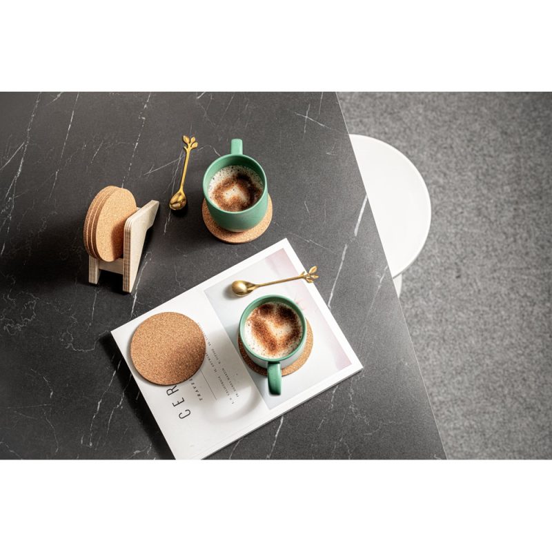 Two cappuccino mugs on a black marble table.