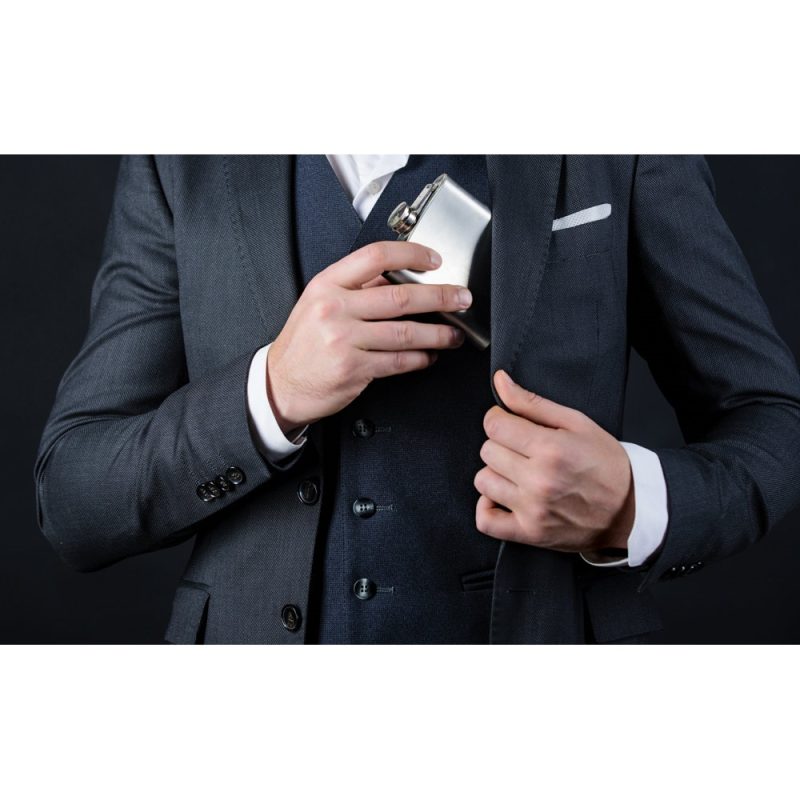 Man storing flask in suit pocket