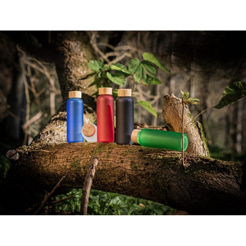 Colourful water bottles on a tree branch in forest.