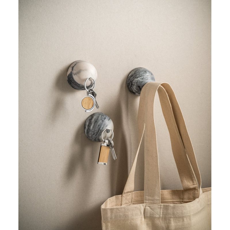Grey hooks holding keys and a beige bag.