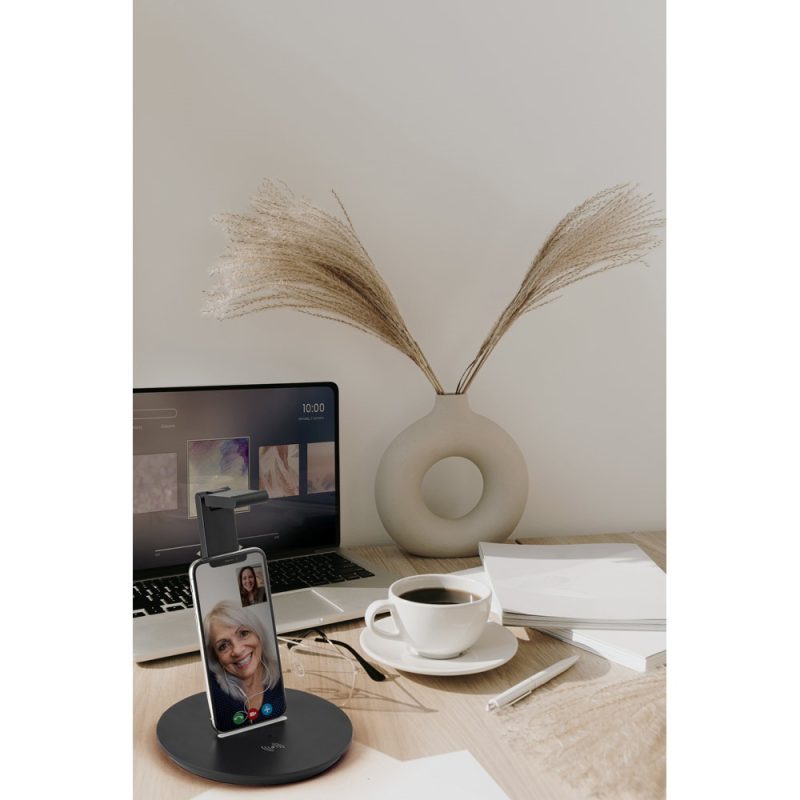 Desktop with phone on stand, laptop, and coffee.