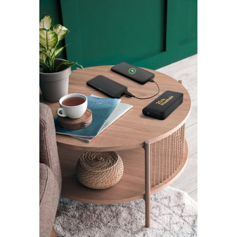 Coffee table with plants, power bank, and charging phones.