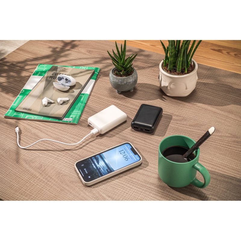 Smartphone charging with power banks on wooden table.