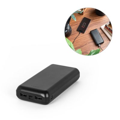 Black power bank charging smartphone on table.