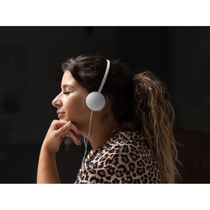 Woman enjoying music with headphones indoors.