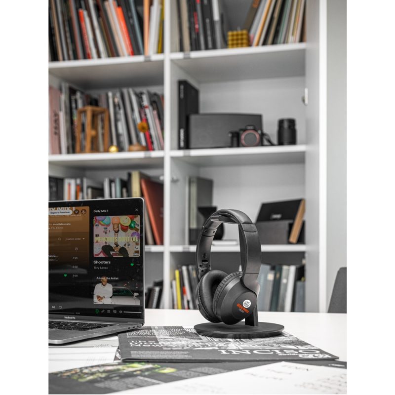 Headphones and laptop with music streaming in office.