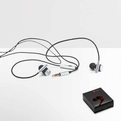 Silver wired earphones with packaging box on table.