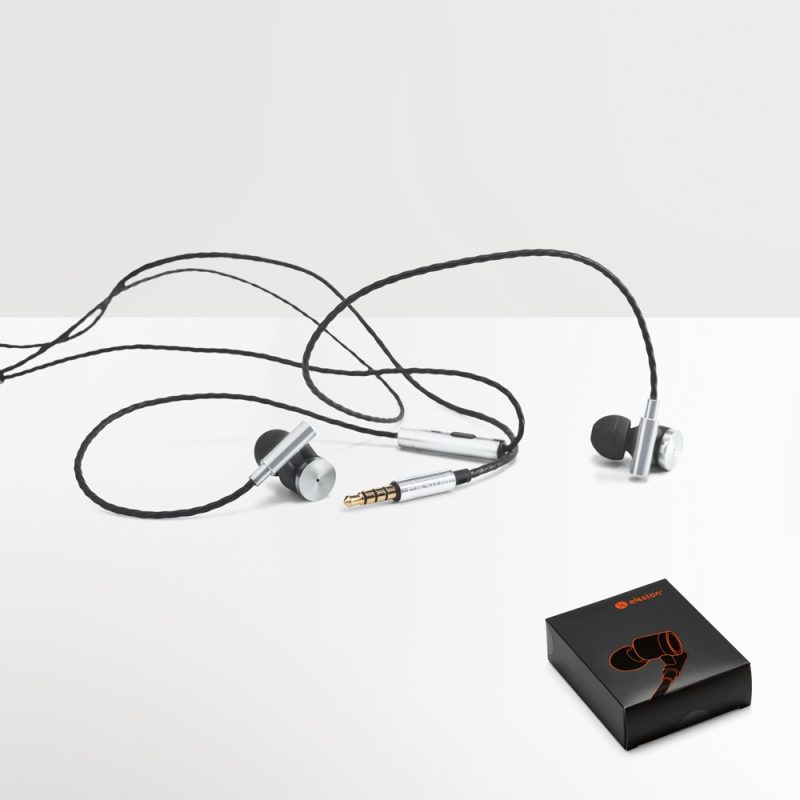 Silver wired earphones with packaging box on table.