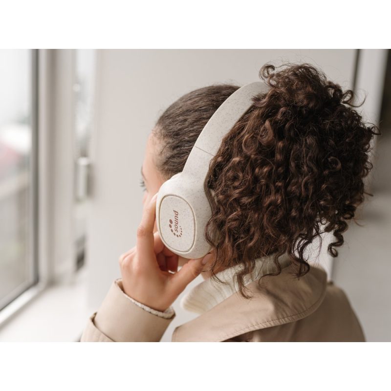 Person listening to music with headphones indoors.